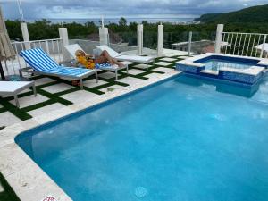 法尔茅斯Luxury 2 Bedroom Rooftop pool View unit #3的躺在游泳池旁椅子上的女人