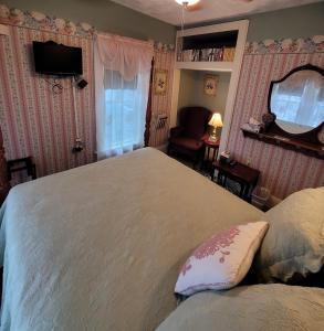 De SmetPrairie House Manor Bed and Breakfast的一间卧室配有一张大床和镜子