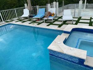 法尔茅斯Luxury 2 Bedroom Rooftop pool View unit #3的坐在游泳池旁椅子上的女人