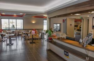 安锡阿纳西王牌酒店的一间带桌椅和柜台的餐厅
