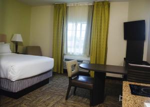 休斯顿休斯顿医疗中心烛木套房酒店的配有一张床、一张桌子和一张桌子的酒店客房
