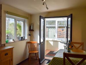 RowlstoneAugustus Cottage的客房设有桌子、椅子和窗户。