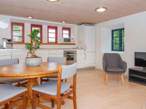 格莱斯堡Holiday home Glesborg CXXX的厨房以及带木桌和椅子的用餐室。
