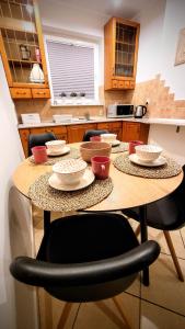 乌斯特卡Apartament DANA piękna plaża wydmy las的厨房里摆放着碗和盘子的桌子