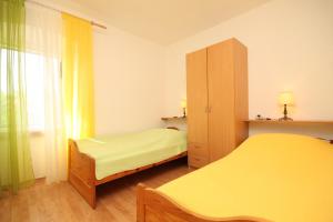 萨利Apartments with a parking space Sali, Dugi otok - 8084的一间带两张床和橱柜的小卧室