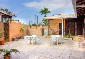 卡拉瓜塔图巴Hostel Carcará的一个带白色桌椅的庭院和一座房子