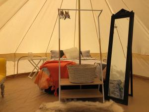 KaihuKai Iwi Lakes Resort的带帐篷、床和镜子的客房