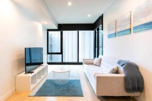 悉尼Lovely One Bedroom + Study with Infinity Pool的带沙发和平面电视的客厅