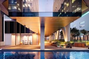 悉尼Lovely One Bedroom + Study with Infinity Pool的建筑前有游泳池的建筑