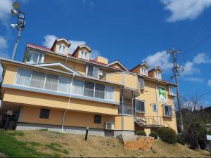 Kusakabeolive no sato vingh four eyes shodoshima / Vacation STAY 79065的山顶上一座黄色的大建筑