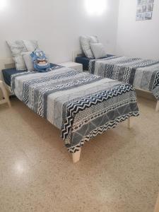苏塞Écrin的配有蓝色和灰色毯子的客房内的两张床
