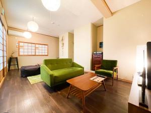 京都Suzuki Guesthouse的客厅配有绿色沙发和桌子