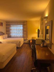 安克雷奇安克雷奇市区华美达酒店的酒店客房配有两张床和一张书桌