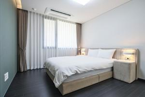 西归浦市Jeju Hana Resort的一间设有大床和窗户的酒店客房