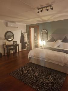 拉塞利亚Meraki Country Manor的一间卧室配有一张床和一张桌子,铺有地毯
