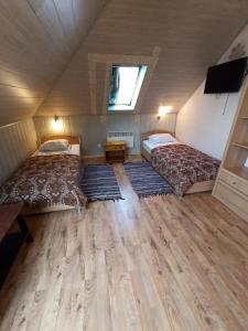 LaagnaHotel Laagna的小型客房铺有木地板,配有两张床。