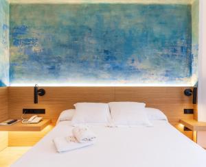 巴古尔Hotel Rosa & Spa Begur的卧室配有白色床,上面有绘画作品