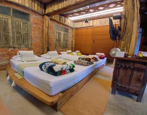 Ban Pok Naiไชยพล โฮมสเตย์ หมู่บ้านแม่กำปอง的一间卧室,配有两张床