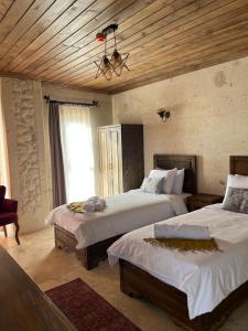 乌奇希萨尔UCHI Cappadocia的一间卧室设有两张床和木制天花板