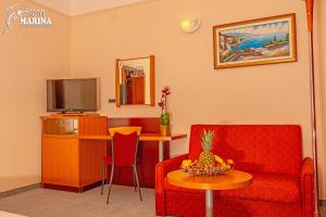 塞尔瑟马里纳酒店的客厅配有沙发和带电视的桌子