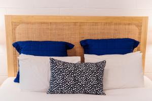 坎贝尔港奥考港口汽车旅馆的一张带蓝色和白色枕头的床和木制床头板