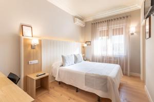 格乔阿塔兹酒店的卧室配有白色的床和窗户。