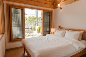 庆州Gyeongju Hanok Sohwa的卧室配有白色的床和窗户。