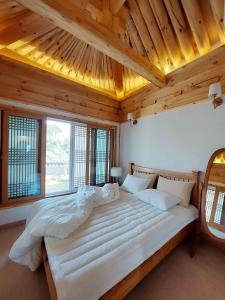 庆州Gyeongju Hanok Sohwa的卧室配有一张白色大床和木制天花板