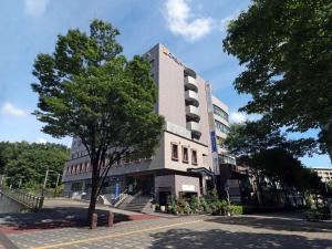 横滨Chisun Inn Yokohama Tsuzuki的前面有一棵树的高楼