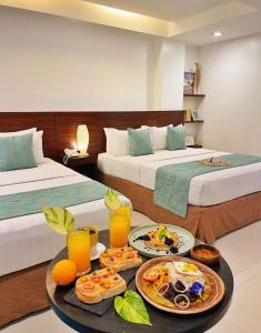 长滩岛乔尼的精品酒店的酒店客房设有两张床和一盘食物