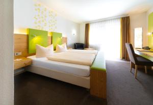 弗莱堡比尔豪斯尔餐厅酒店的配有一张床和一张书桌的酒店客房