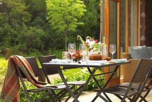 斯尼姆The Woodland Villas at Parknasilla Resort的天井上配有带酒杯和鲜花的桌子