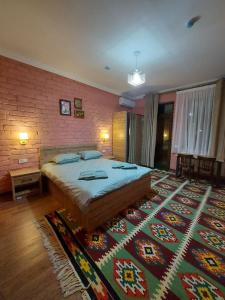 撒马尔罕MUSAVVIR的一间卧室设有一张大床和砖墙