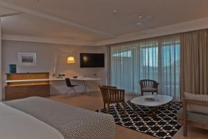 赫索尼索斯克里特高尔夫俱乐部酒店的酒店客房带一张床、一张桌子和椅子