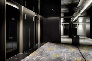 熊本KOKO HOTEL Premier Kumamoto的走廊设有黑色墙壁和瓷砖地板。