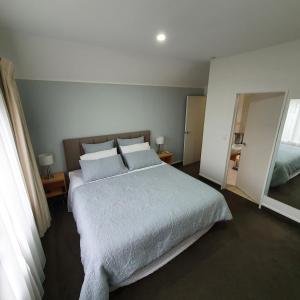 陶波Midtown Tui Villa - Taupō Central Holiday Unit的卧室配有一张带白色床单和枕头的大床。