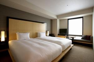 金泽KOKO HOTEL Premier Kanazawa Korinbo的一张大白色的床,位于酒店客房内