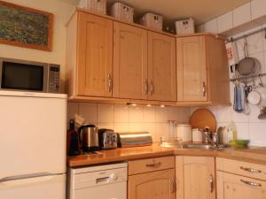 南达Apartment Montfort 9A by Interhome的厨房配有木制橱柜和白色冰箱。