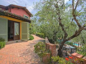 尼阿博勒皮耶韦Apartment Borgo della Limonaia-1 by Interhome的树旁有砖砌车道的房子