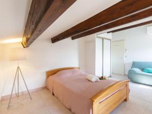 圣艾格夫Apartment Le Panama-3 by Interhome的一间卧室配有一张床和一张蓝色的沙发