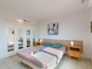 圣艾格夫Apartment Les Mimosas-1 by Interhome的一间卧室配有一张大床和一个床头柜