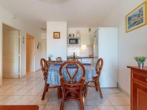 圣艾格夫Apartment Les Calanques du Parc-3 by Interhome的厨房配有桌椅和冰箱。