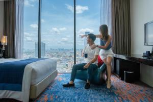 曼谷曼谷暹罗智选假日酒店的坐在酒店带窗户的房间的男女