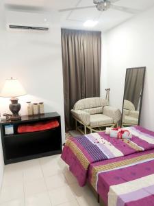 万挠Islamic Homestay Apartment Kundang, Rawang的一间卧室配有一张床、一张沙发和一把椅子