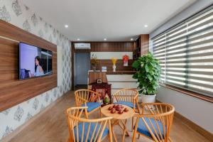 富国Coco Homestay的一间带桌椅和电视的用餐室