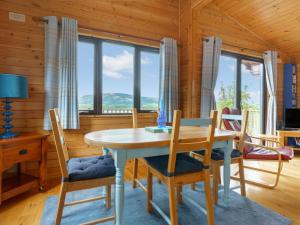 金罗斯Chalet Lodge 9 by Interhome的一间带桌椅和窗户的用餐室