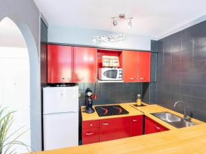艾姆布里亚布拉瓦Apartment Puigmal by Interhome的厨房配有红色橱柜和白色冰箱