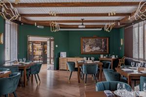 休钦斯克Дом у озера的餐厅设有木桌和椅子,拥有绿色的墙壁