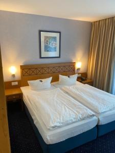 巴贝西斯特恩海滨酒店的卧室配有一张带白色床单和枕头的大床。