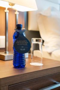 第比利斯考斯特酒店的玻璃旁边的桌子上的蓝色瓶子